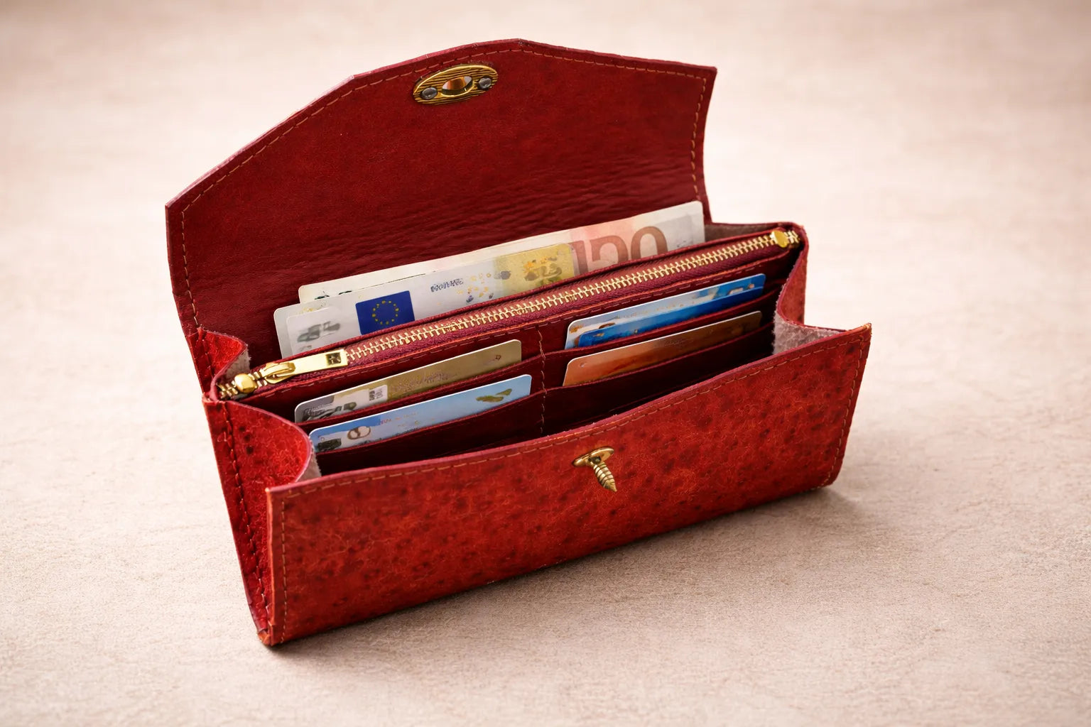 Sisäkuva avatusta Toe-Nahka Designin punaisesta nahkalompakosta, jossa on useita korttipaikkoja, setelitasku ja vetoketjullinen kolikkotasku – käytännöllinen ja tilava käsintehty lompakko.