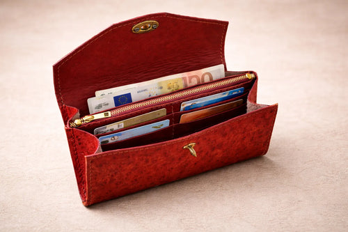 Sisäkuva avatusta Toe-Nahka Designin punaisesta nahkalompakosta, jossa on useita korttipaikkoja, setelitasku ja vetoketjullinen kolikkotasku – käytännöllinen ja tilava käsintehty lompakko.